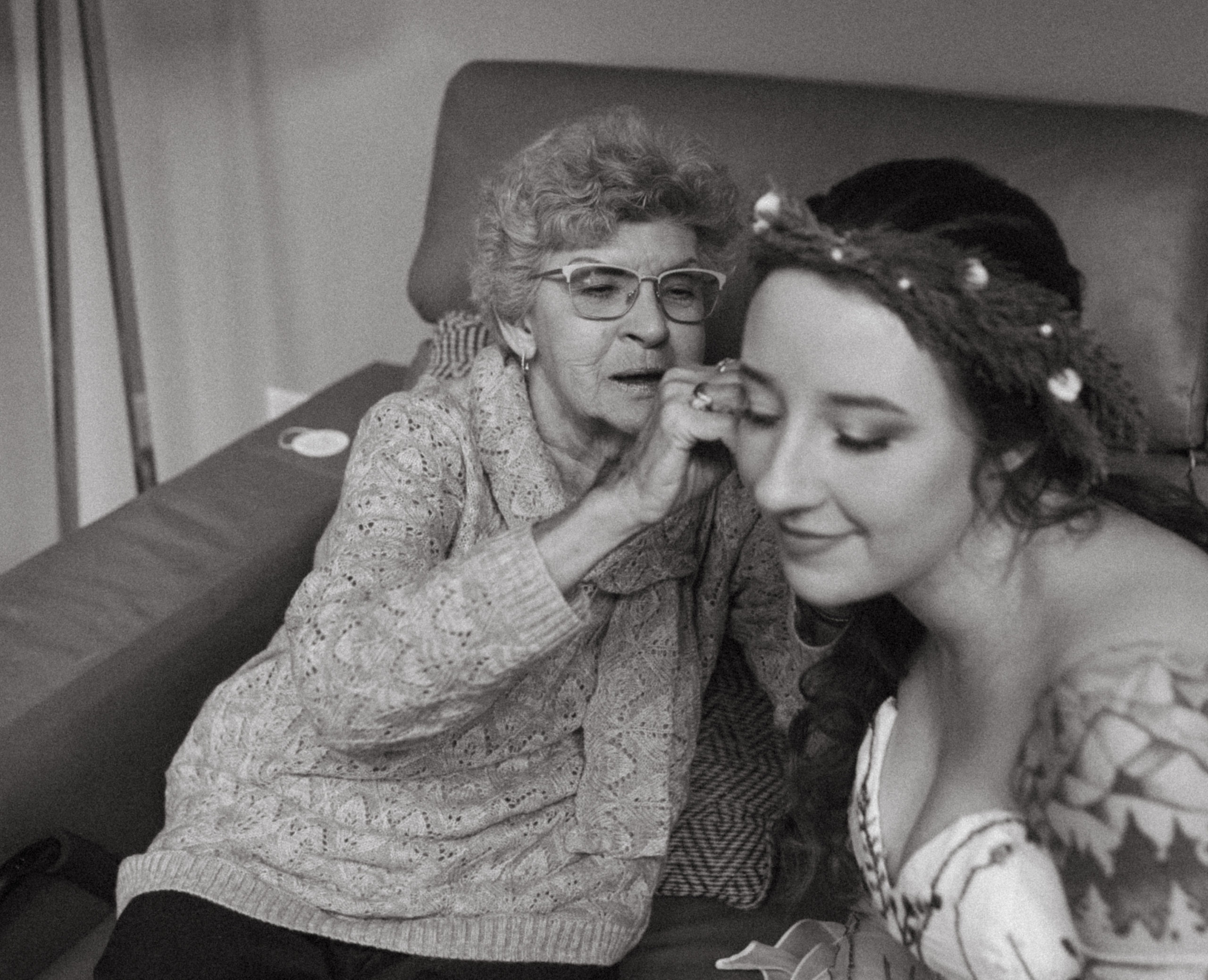 The bride's grandmother helps her put on her earrings for her wedding ceremony in the blue ridge mountains of North Carolina