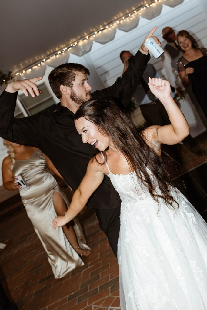 Bride and groom dancing joyfully with guests at a North Carolina outdoor wedding reception