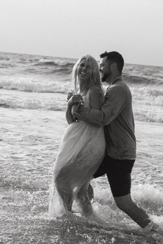 Couple embracing during a sunrise session with Wrightsville Beach couples photographer